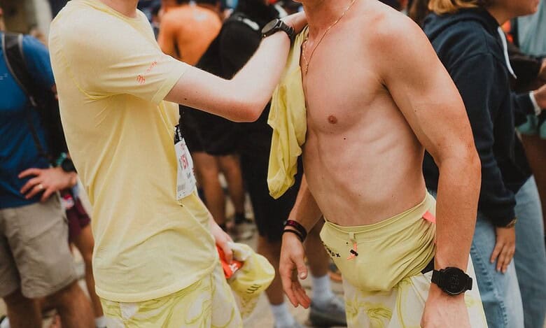 A young runner is showing support and camaraderie at a race event, highlighting sportsmanship and the emotional moments experienced by runners.
