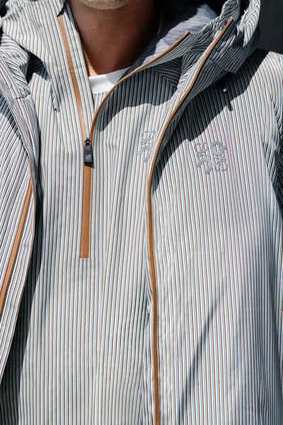 Light blue and white striped running jacket with breathable fabric and waterproof features, ideal for outdoor running in various weather conditions.