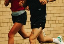 Running insights, athletes training outdoors, running on a wet surface, focusing on performance and endurance, wearing sportswear, brick wall background, passionate runners enhancing their fitness.