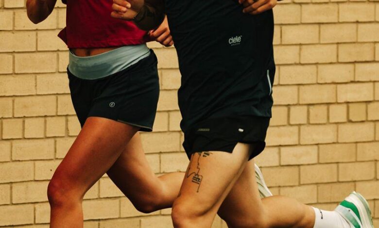 Running insights, athletes training outdoors, running on a wet surface, focusing on performance and endurance, wearing sportswear, brick wall background, passionate runners enhancing their fitness.