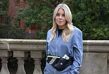 Athletic woman in running gear with water bottle, outdoor park setting, fitness, training, running accessories, healthy lifestyle, sportswear, outdoor exercise, running companion, hydration, urban running, female runner, fitness motivation, activewear, sport performance.