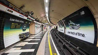 Modern New Balance sneaker displayed in Waterloo Tube station with an advertisement promoting "Lose track of time" for the running and footwear brand.