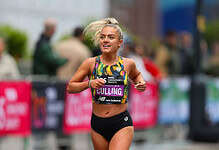 Female marathon runner smiling and running outdoors, showcasing improved energy and strength after dietary changes.