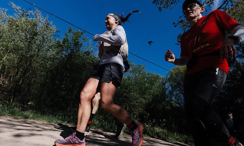 Female runner Sarah Perry finishing the Legends race, showcasing endurance and determination on a sunny trail.