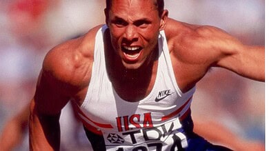 Athlete in mid-race sprint, showcasing explosive power and speed during a track event.