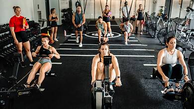 Indoor rowing athletes using data-driven testing methods at a modern gym.