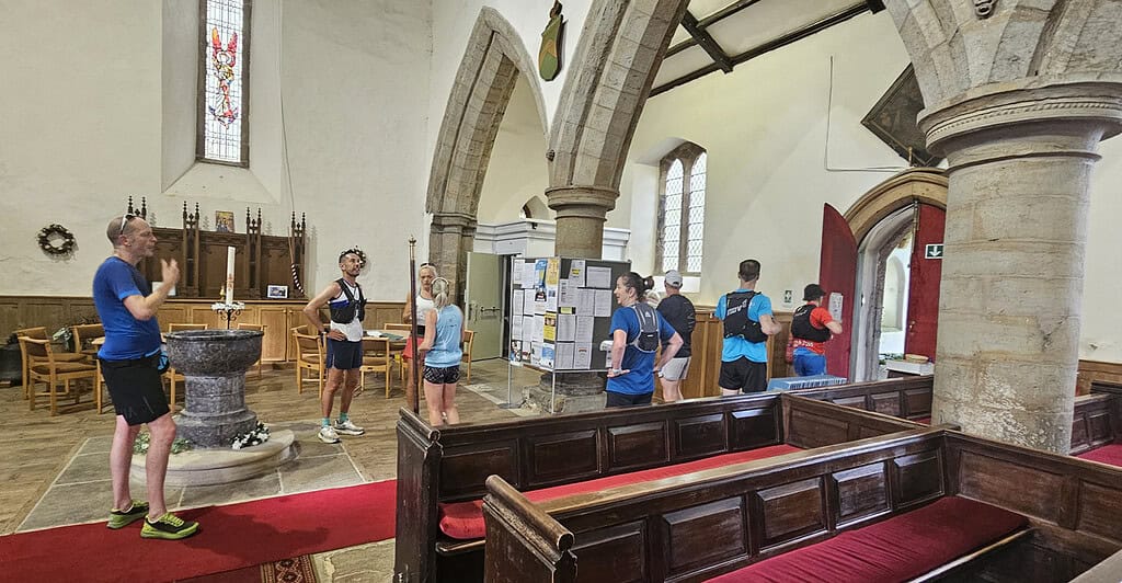 Running Insights team participating in a running event inside a historic church, with runners preparing and receiving instructions before the race, highlighting community and athletic spirit.
