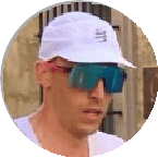 Close-up of a runner wearing a white cap and sunglasses during a training session, highlighting running gear and outdoor environment.