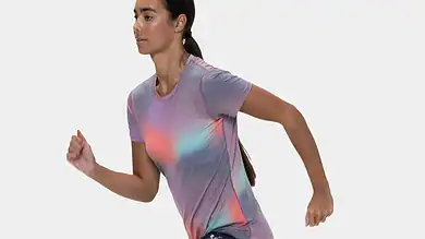 Female runner in athletic gear captured mid-stride, showcasing dynamic movement and focus, ideal for running and fitness content.