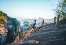 A trail runner crossing a mountain path above Wuyishan’s sandstone peaks