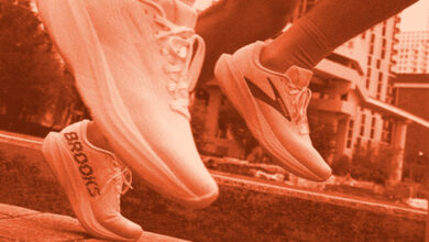 Two runners' feet in motion on a city path, showcasing athletic sneakers branded for running performance.
