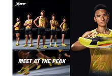 Young male athlete showcasing yellow and black running shoes for performance and style, with a professional studio background.