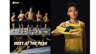 Young male athlete showcasing yellow and black running shoes for performance and style, with a professional studio background.